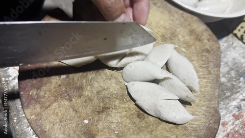 Asian cook is cooking in thai kitchen in local traditional country style, preparing fresh fish balls to cook thai food green curry popular worldwide
