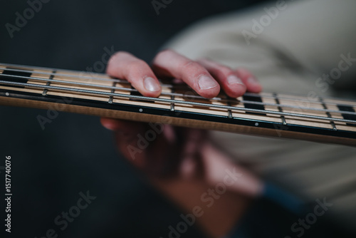 Quadro su tela Detailed photograph of a musician's hand pressing guitar strings, emphasizing the craftsmanship of the instrument and the concentration required during play