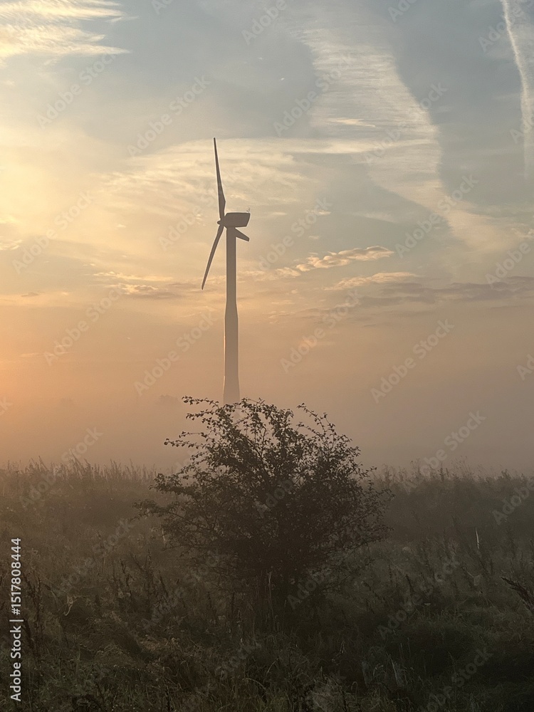 Obraz premium wind turbine in the field in the sunrise a foggy morning