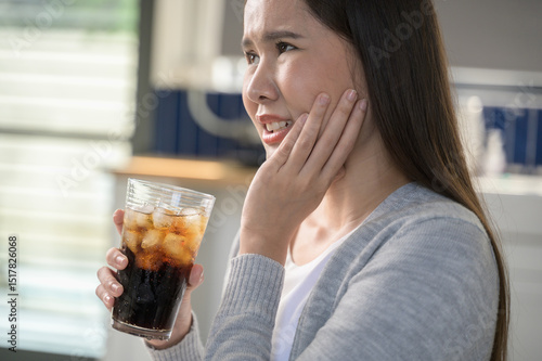 Quadro em tela Young Asian woman touching her cheek and mouth feeling pain from toothache, decay or sensitivity cavity molar tooth or inflammation cause by drink cold, sparkling water
