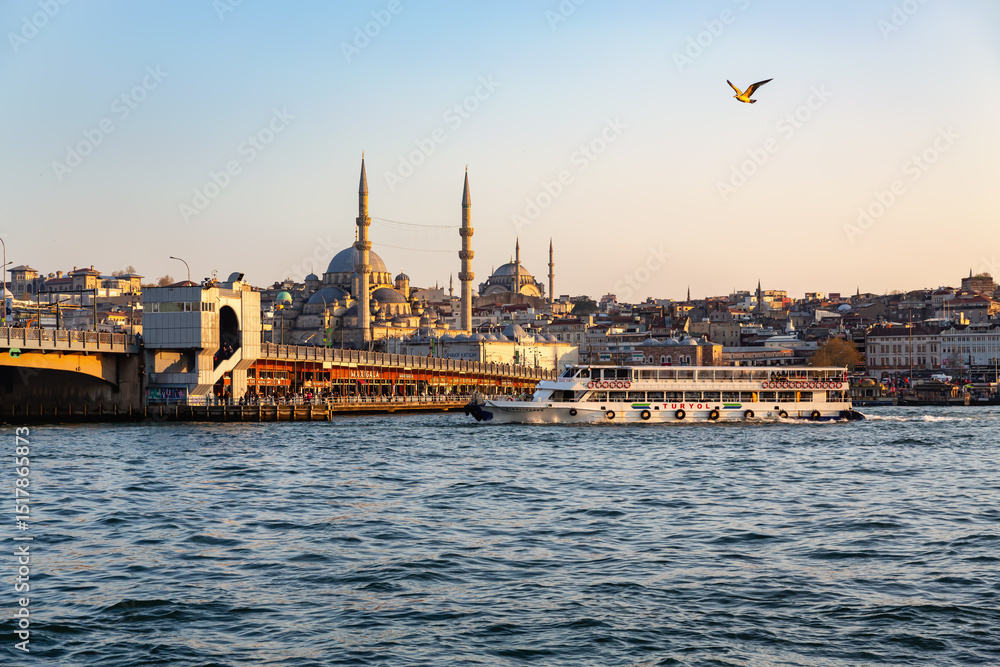 Naklejka premium Galata Bridge and mosque skyline in Istanbul, Turkey during golden hour