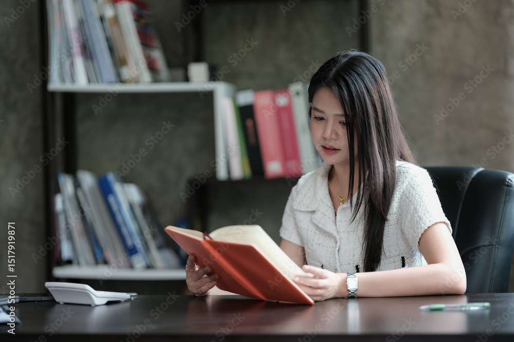 An Asian businesswoman is reading a book. An Asian businesswoman is reading a book.