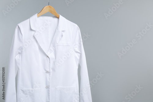 Billede på lærred Doctor's coat on hanger against grey background. Space for text