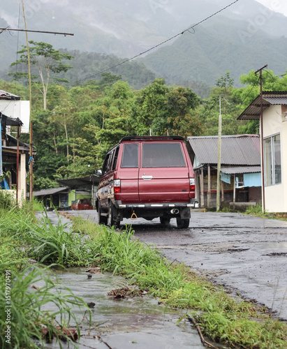 Red car on a mountain road in Indonesia.