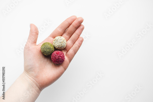 Bild auf Leinwand Colorful vegan candy energy balls on womans hand