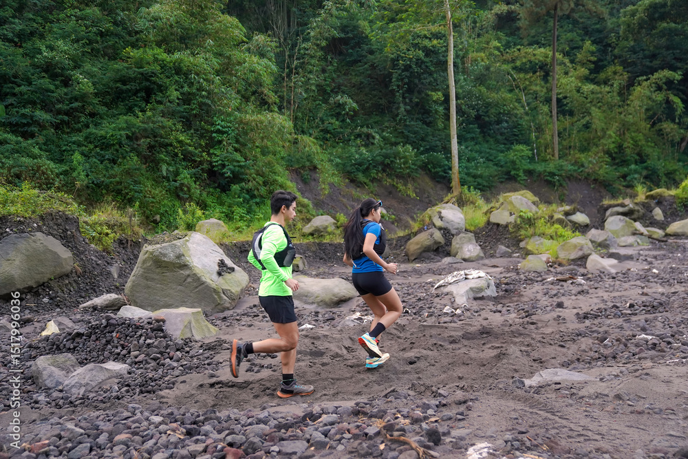 Fototapeta premium Asian Trail Runners Jogging on Rocky Path in Forested Mountain Area