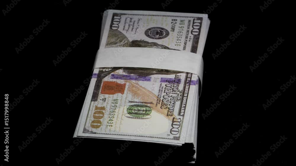 A stack of 100 hundred-dollar bills on a black background with beautiful lighting, 360-degree rotating video. 4k video. A stack of 100 hundred-dollar bills on a black background with beautiful lighting, 360-degree rotating video. 4k video.