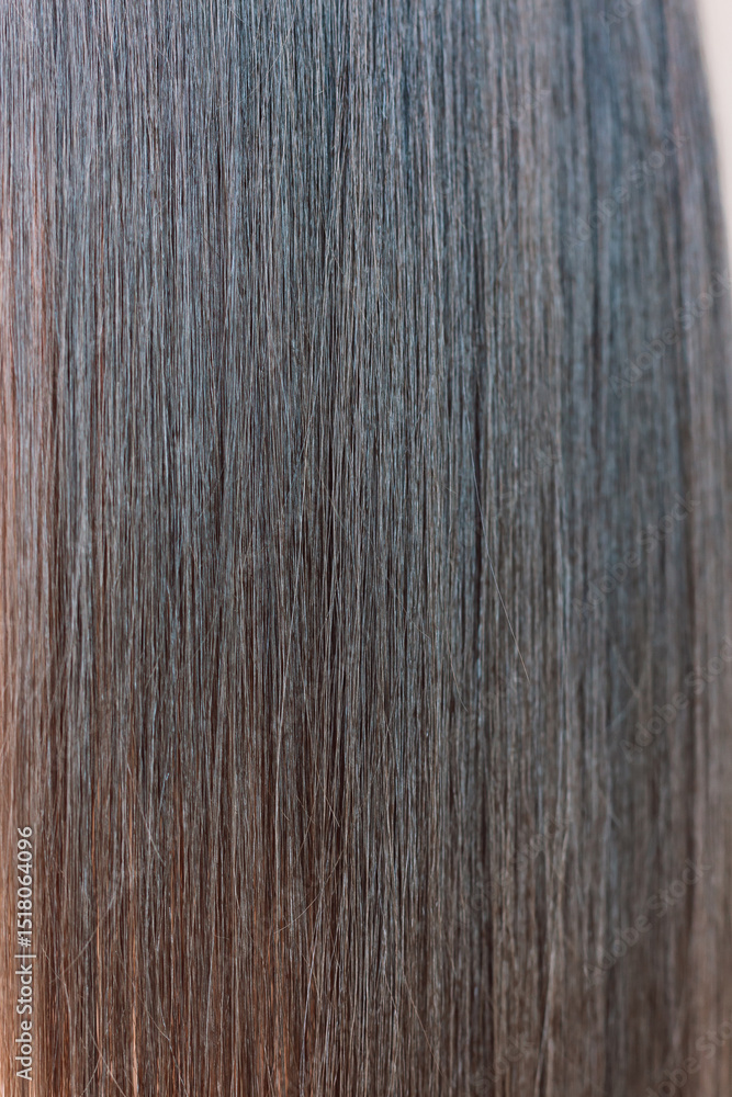 Naklejka premium Close-up of a brunette woman's beautiful long smooth healthy hair. Vertical photo