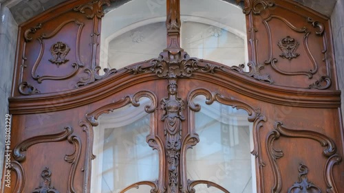 Elegant wooden door with intricate carvings and glass panels. Exquisite craftsmanship is showcased in this wooden door, featuring elaborate carvings, decorative glass panels, and ornate details