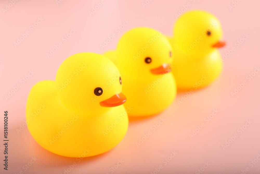 Three cute rubber ducks on pink background, closeup Three cute rubber ducks on pink background, closeup