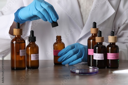Foto Professional perfumer developing luxury perfume at wooden table in laboratory, c