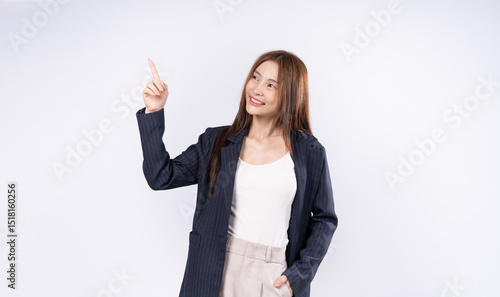 Beautiful Asian woman in suit raising hand pointing finger upwards smiling face photo in studio on white background