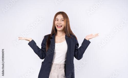 Beautiful Asian woman in suit raising both hands showing product presentation with confidence and friendly smile.