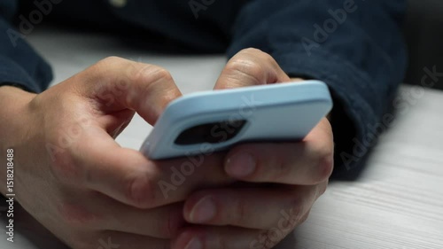 A guy uses a mobile phone for social networks.
Online correspondence on the phone.
A man with a blue phone in his hands, close-up.
Phone, smartphone, blue, hand