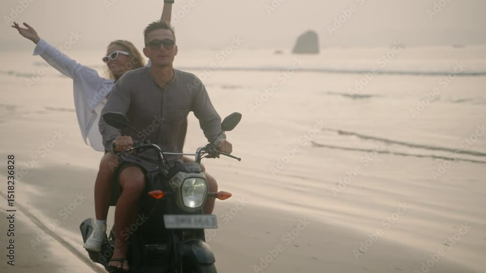 custom made wallpaper toronto digitalElegant couple ride motorcycle along sea beach on sunrise. Intraframe installation from bike to people. Tourists drive rented motorbike on ocean coast. Woman hugs man, spreads arms riding scooter.