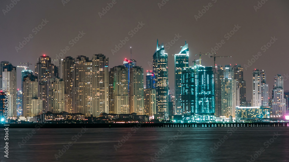 Fototapeta premium Dubai Marina skyline night timelapse as seen from island in Dubai, UAE.