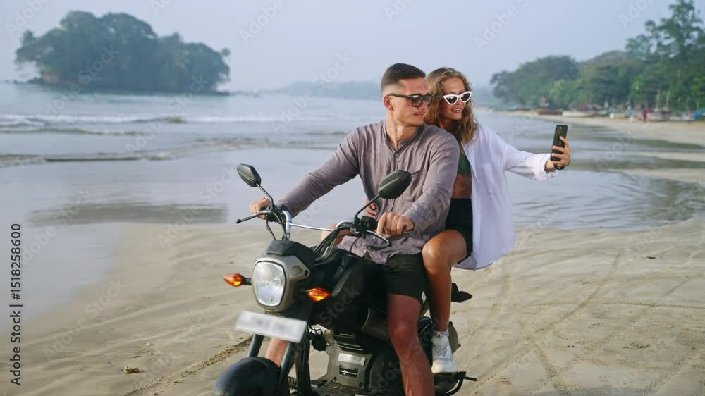 custom made wallpaper toronto digitalYoung romantic couple sit on motorcycle on sea beach at sunset. Female travel blogger filming vlog, taking selfie photo on smartphone. Man, woman in love relax on motorbike trip to ocean coast.