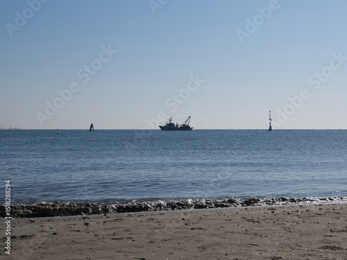 Po Delta, Ferrara province, northern Italy. Volano beach, panorama with fishing boat.