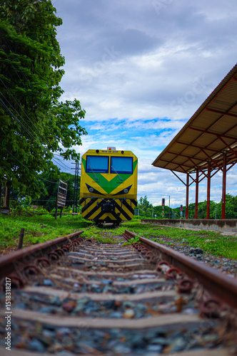 The old train sits quietly on the weathered but still historic tracks. The faded paint and worn stripes tell the story of the journey and the train remains a symbol of travel, memories and echoes from