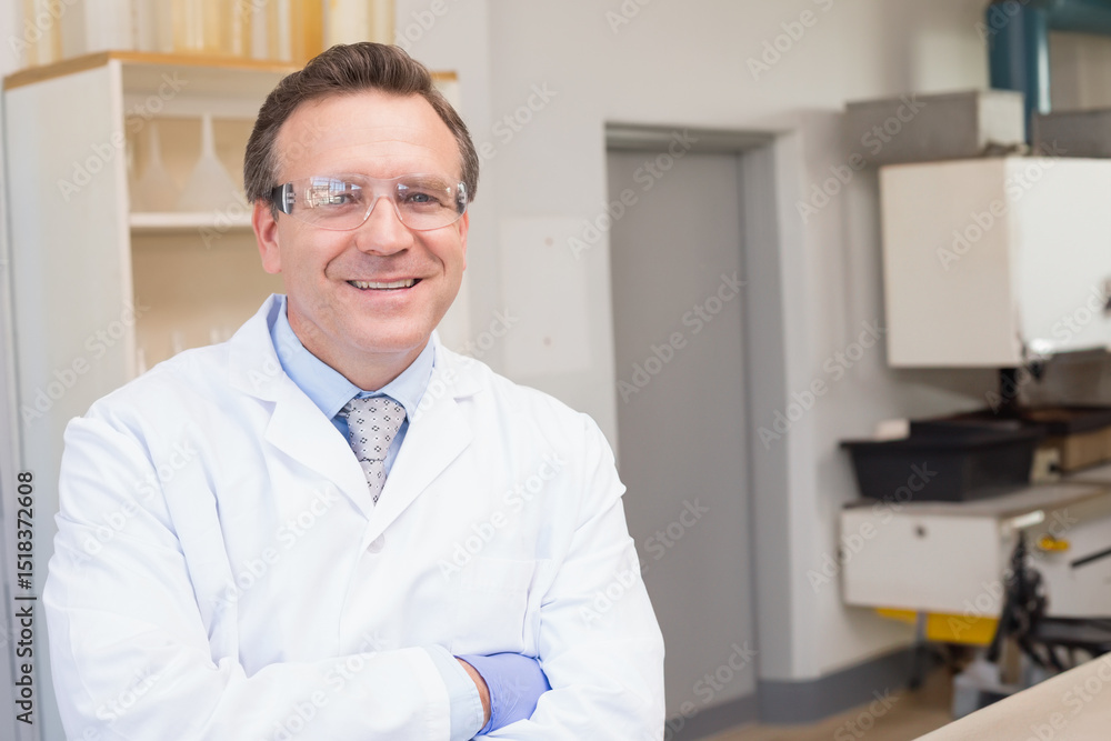 Mature male scientist standing arms crossed in lab wearing lab coat, gloves and glasses, copy space Mature male scientist standing arms crossed in lab wearing lab coat, gloves and glasses, copy space