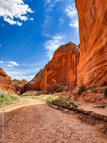 Foto hiking trail beneath red sandstone cliffs leading into slot canyons in Southern