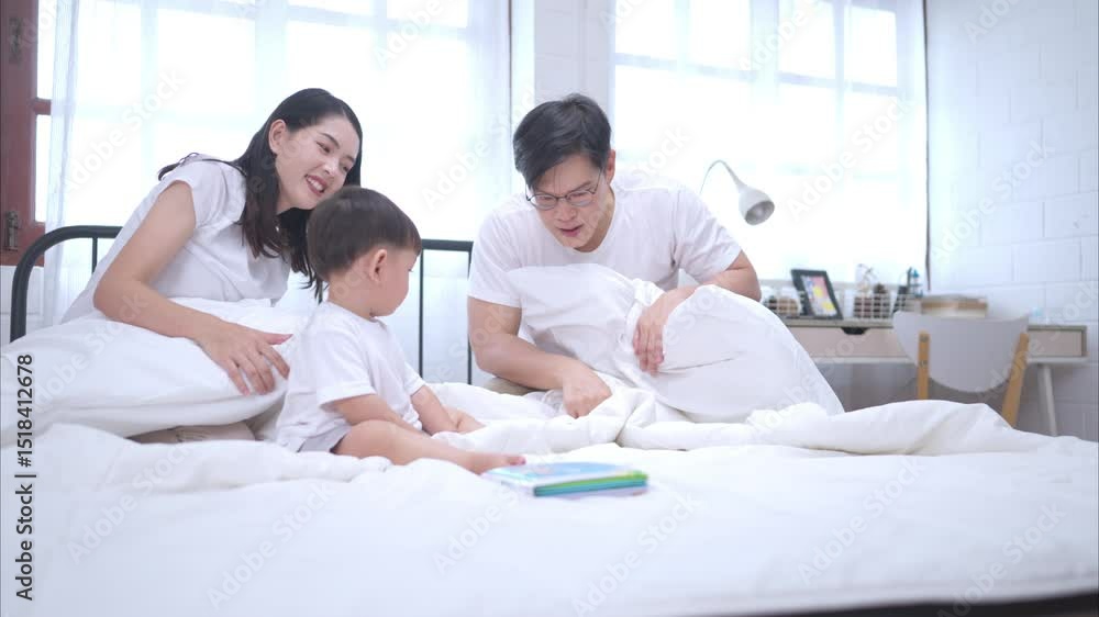Before putting the kids to bed, parents, and kid unwind and play in the bedroom Before putting the kids to bed, parents, and kid unwind and play in the bedroom
