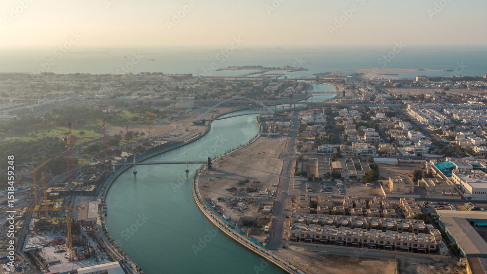 Fototapeta premium Dubai water canal with footbridge during sunset aerial timelapse from Downtown skyscrapers rooftop