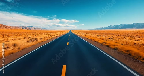 FPV drone footage captures a straight road through a vast desert landscape towards distant mountains under a bright blue sky.