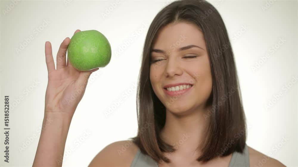 Confident athletic woman joyfully holding a green apple Confident athletic woman joyfully holding a green apple