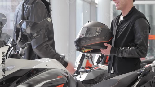 Seller hands over a sleek motorbike helmet to an enthusiastic buyer