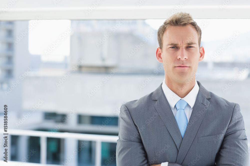 Gray-suited man standing by balcony railing looking confident in light-blue tie, copy space Gray-suited man standing by balcony railing looking confident in light-blue tie, copy space