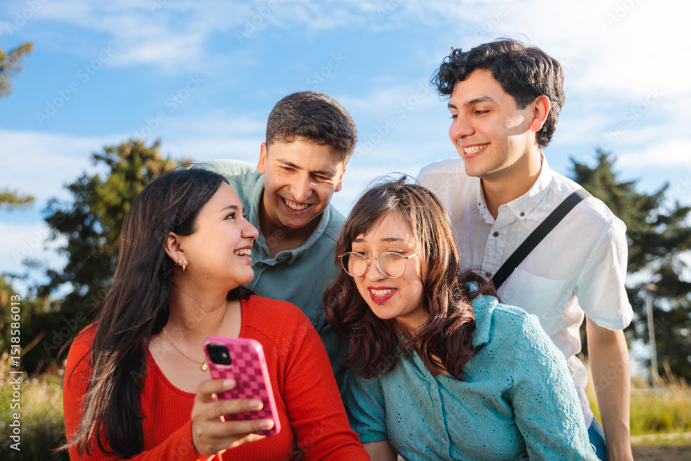 Obraz premium Group of young students using mobile phone in a park