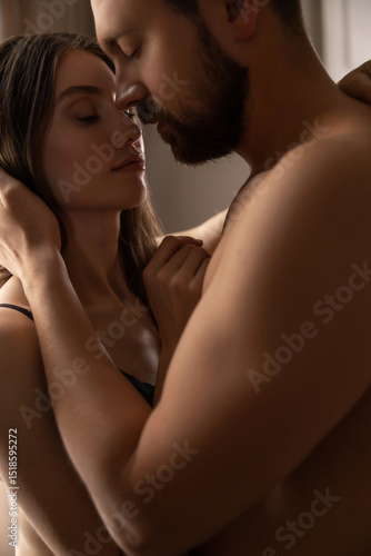 Woman cuddling her attractive partner in house lovers touching tenderly