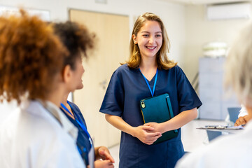 Young nurse smiling during hospital meeting with medical team