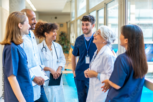 Medical team talking and smiling in hospital corridor