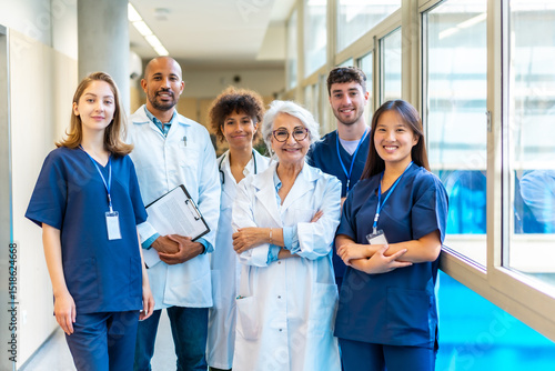 Medical team posing in hospital corridor, healthcare professionals united