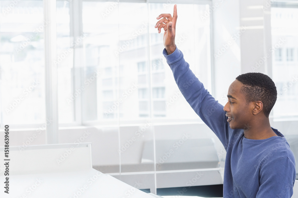 African American man raising hand while sitting at desk in office with glass partition, copy space African American man raising hand while sitting at desk in office with glass partition, copy space