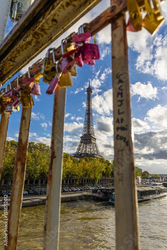 The Eiffel Tower seen through a bridge opening with locks