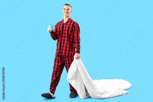 Young man with blanket drin...