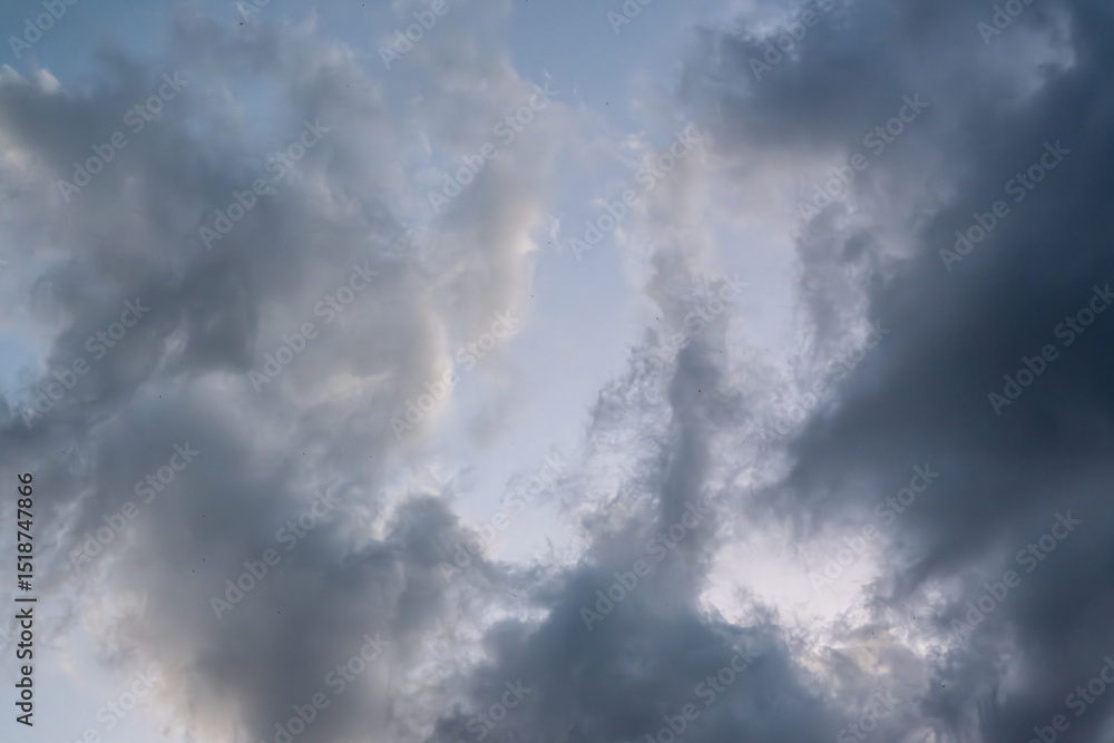 Fototapeta premium Dramatic cloudy sky before a storm, with swirling dark and light cloud formations. Ideal for background or texture use.