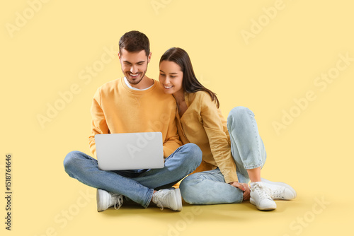 Happy young couple with lap...