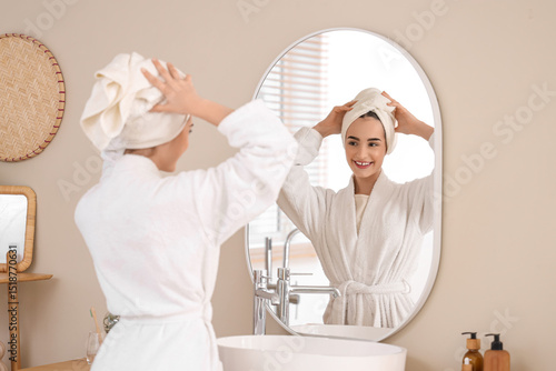 Young woman looking in mirr...