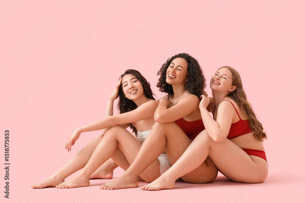 Young body positive women in underwear sitting on pink background Young body positive women in underwear sitting on pink background