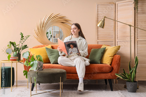 Young woman reading magazin...