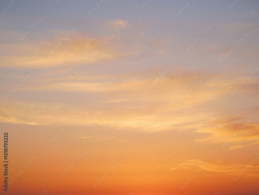 Fototapeta premium Tranquil sky during sunset with soft orange and yellow hues blending into light blue with wispy clouds