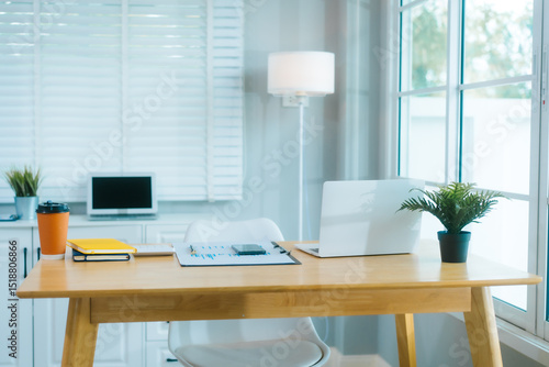 Foto .A clean, modern home office features a laptop, plant, and organized desk, ready