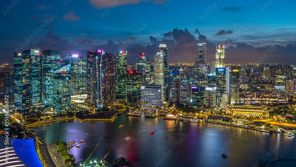 Naklejka premium Aerial view of Singapore business district skyscrapers at evening with water reflections day to night timelapse