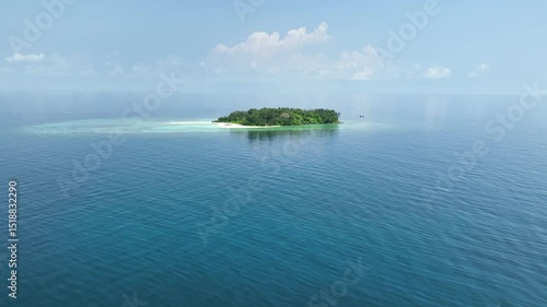 Aerial view of a small, uninhabited tropical island near Karimunjawa, featuring pristine beaches, lush vegetation, and surrounding coral reefs.