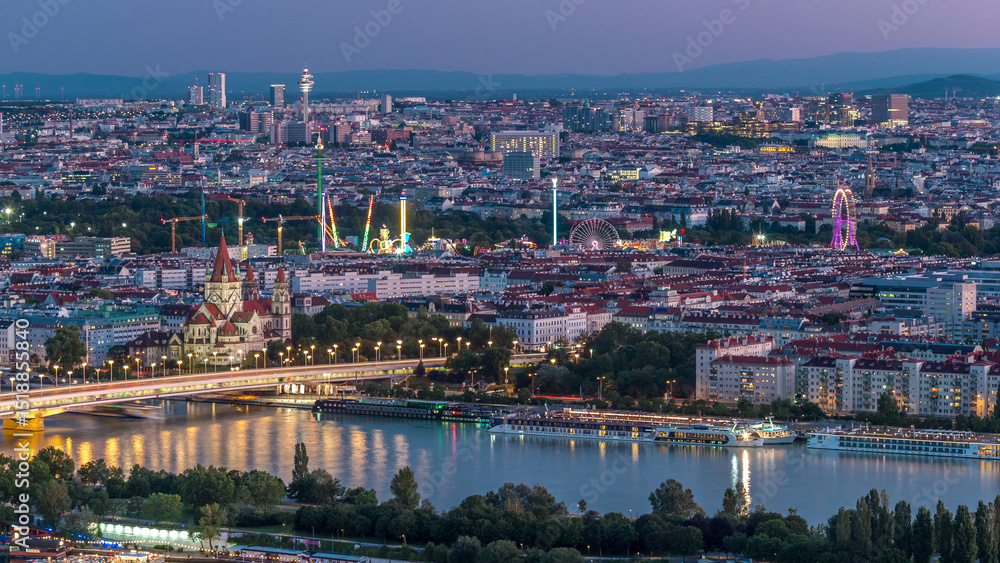 Fototapeta premium Aerial panoramic view over Vienna city with skyscrapers, historic buildings and a riverside promenade day to night timelapse in Austria.