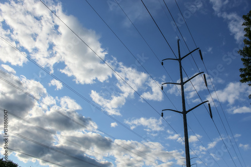 Power lines isolated against a cloudscape abstract modern background.  Steel single-pole overhead transmission line design element with copy space. Energy, development, and environment.